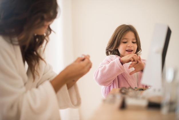 Menina brincando com sua mãe jóias e maquiagem