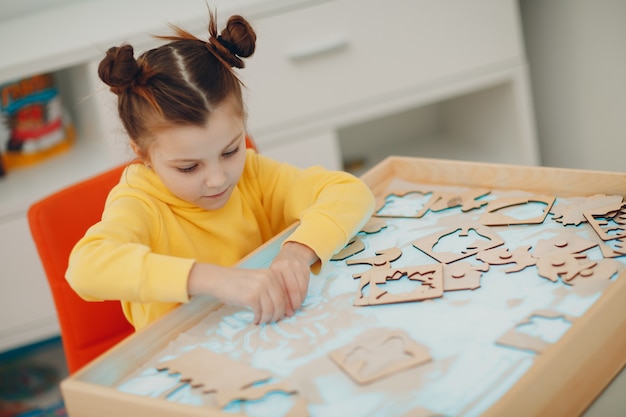 Menina brincando com um brinquedo de forma de areia. Educação infantil. Conceito de psicologia cognitiva da criança.