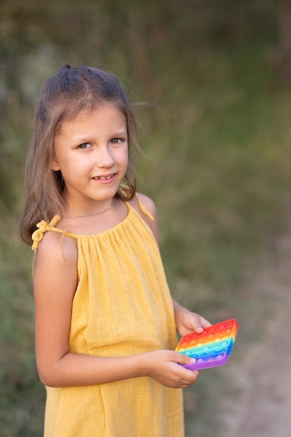 Menina brincando com um brinquedo que abre, na natureza