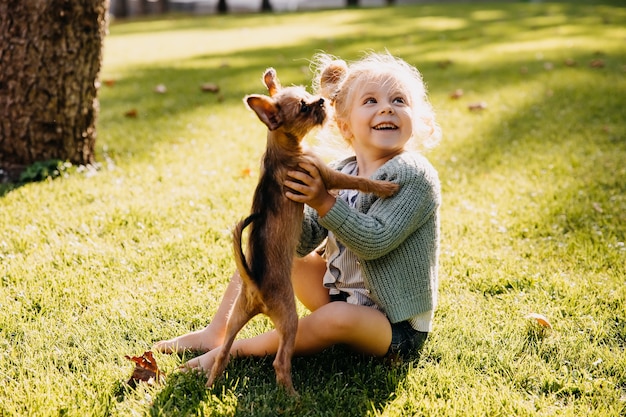Menina brincando com um cachorrinho ao ar livre