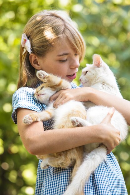 Menina brincando com um gatinho ao ar livre no parque