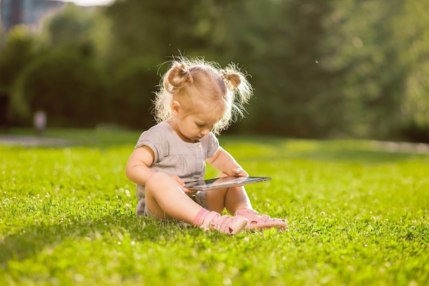 Menina brincando com um tablet no parque