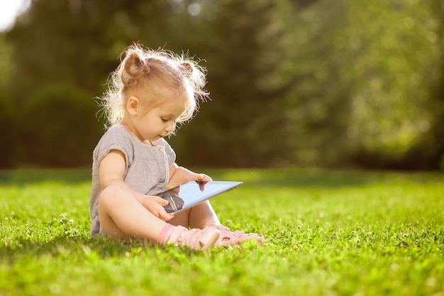 Menina brincando com um tablet no parque