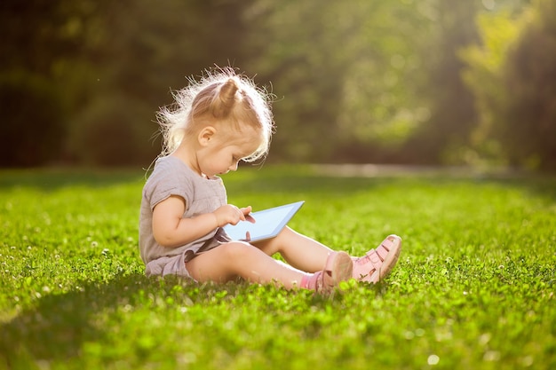 Menina brincando com um tablet no parque