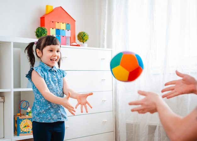 Menina brincando com uma bola na sala de jogos.