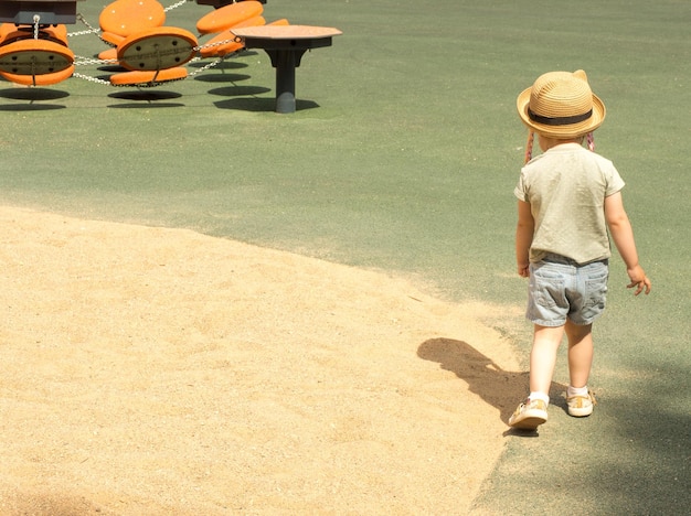 Menina brincando na areia no playground em um dia de verão