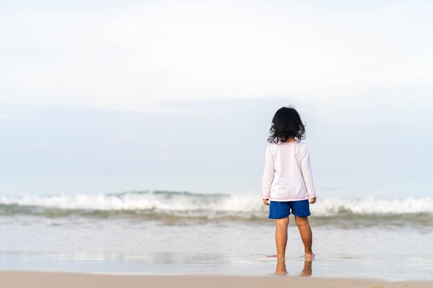 Menina brincando na bela costa do mar.