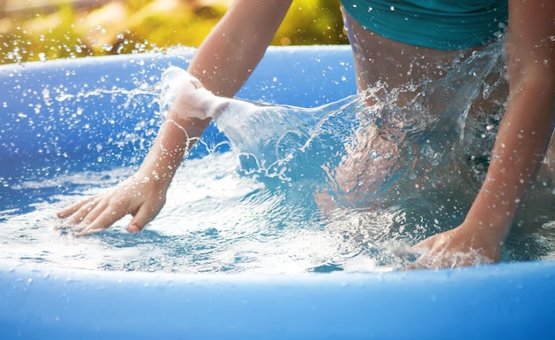 Menina brincando na piscina ao ar livre no verão