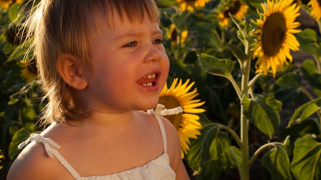 Menina brincando no campo de girassol.