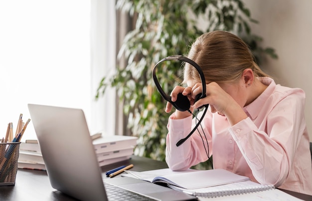 Menina cansada enquanto segura seus fones de ouvido