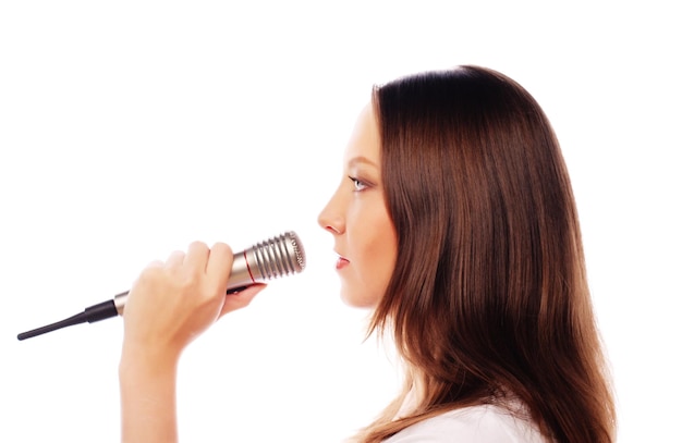 Menina cantora feliz Mulher de beleza vestindo camisa branca com microfone sobre fundo branco