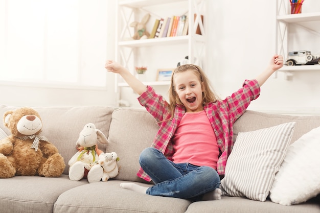 Menina casual com as mãos levantadas em casa