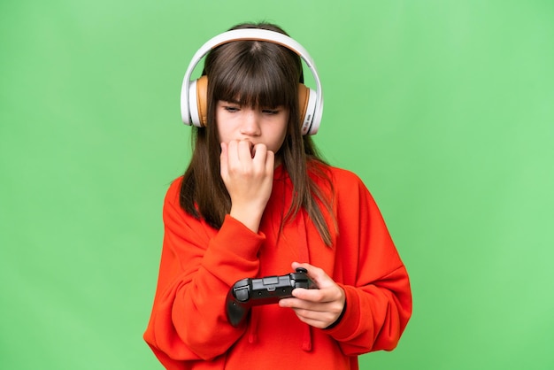 Menina caucasiana brincando com um controlador de videogame sobre fundo isolado com dúvidas