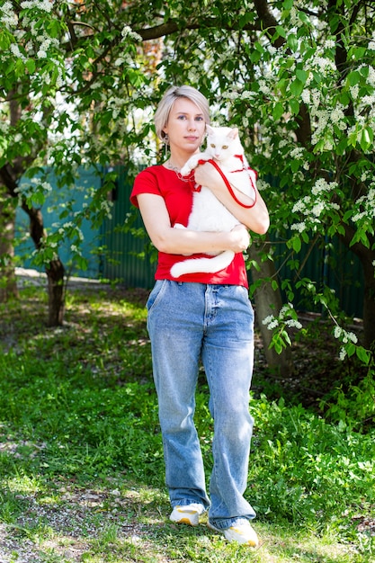 Menina caucasiana caminhando no parque com seu gato