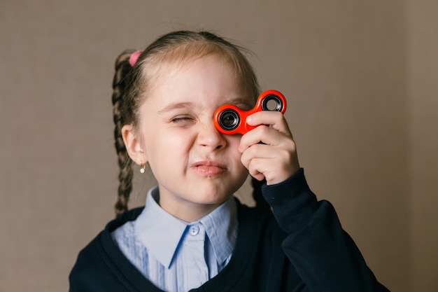 Foto menina caucasiana com fidget spinner apontando para os olhos