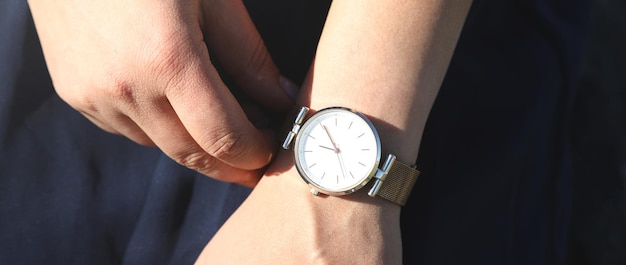 Menina caucasiana com um relógio de pulso na mão
