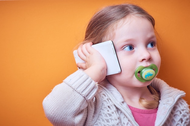 Menina caucasiana com um telefone na mão em um colorido