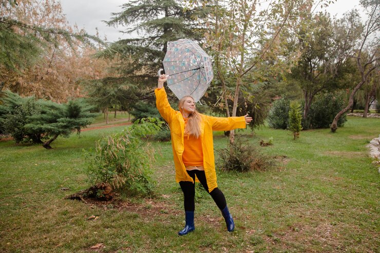 Foto menina caucasiana com uma capa de chuva amarela andando do lado de fora em um dia chuvoso no outono pessoas no outono