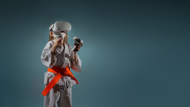 Menina caucasiana com uniforme de caratê jogando videogame com fone de ouvido vr