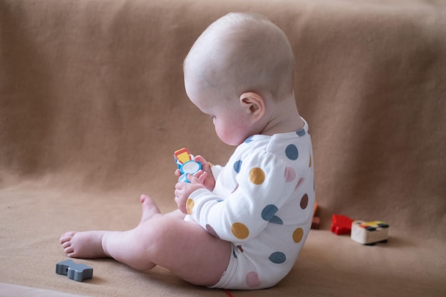 Menina caucasiana de 8 meses brincando com brinquedo em casa