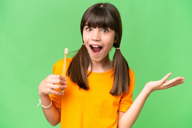 Menina caucasiana escovando os dentes sobre fundo isolado com expressão facial chocada