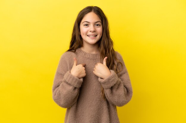 Menina caucasiana isolada em fundo amarelo com expressão facial surpresa