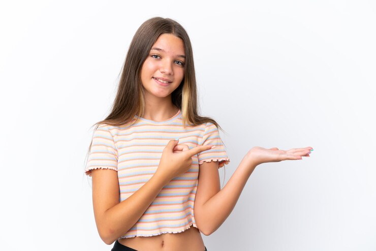 Foto menina caucasiana isolada em fundo branco segurando copyspace imaginário na palma da mão para inserir um anúncio
