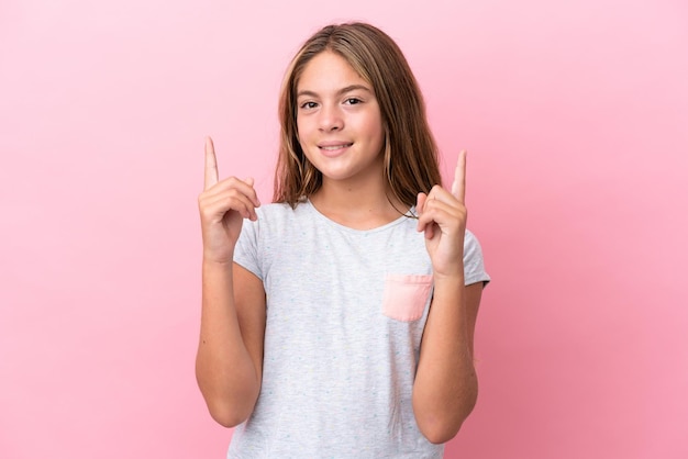 Menina caucasiana isolada em fundo rosa apontando uma ótima ideia