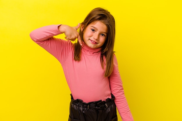 Menina caucasiana isolada em uma pessoa amarela apontando com a mão para um espaço de cópia de camisa, orgulhosa e confiante