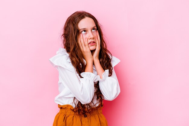 Menina caucasiana isolada na rosa choramingando e chorando desconsoladamente.