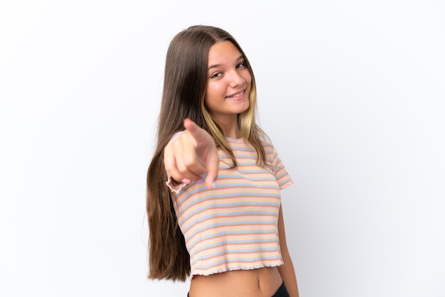 Menina caucasiana isolada no fundo branco apontando para a frente com uma expressão feliz