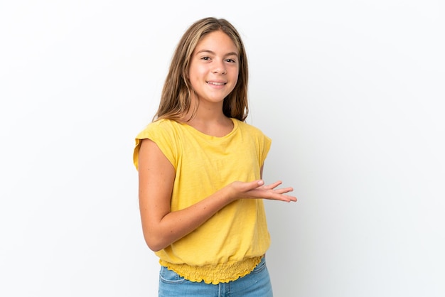 Menina caucasiana isolada no fundo branco apresentando uma ideia enquanto olha sorrindo para