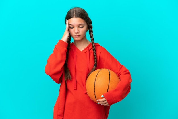 Menina caucasiana jogando basquete isolada em um fundo azul com dor de cabeça