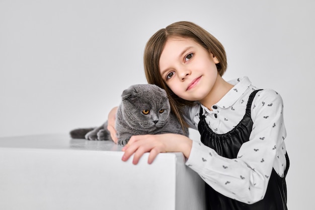 Menina caucasiana segurando o gato nos braços