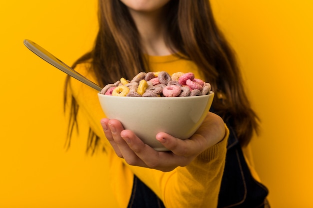 Menina caucasiana segurando uma tigela de cereais