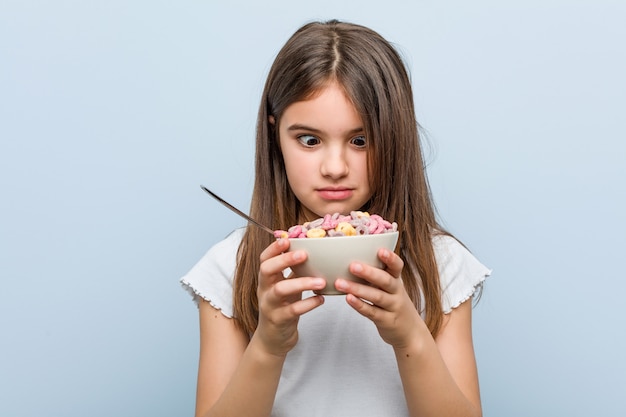 Menina caucasiana segurando uma tigela de cereais