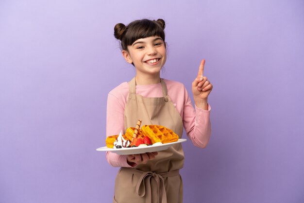 Menina caucasiana segurando waffles isolados