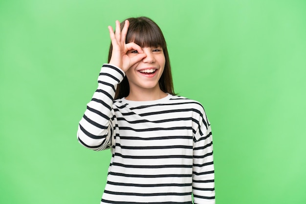 Menina caucasiana sobre fundo isolado mostrando sinal de ok com os dedos