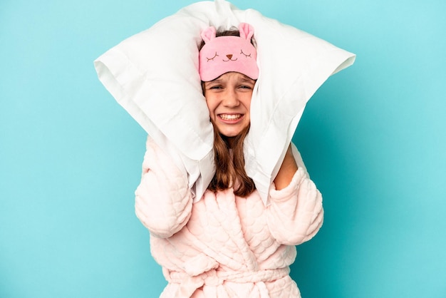 Menina caucasiana vai dormir isolada num fundo azul