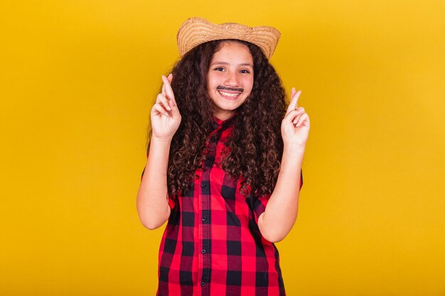 Menina caucasiana vestida como uma roupa de festa de menino dedos cruzados torcendo desejando festivais esperançosos em maio, junho e julho