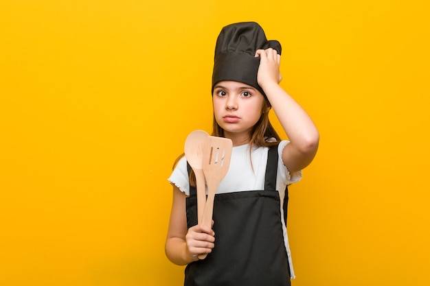 Menina caucasiana vestindo uma fantasia de chef, ficando em choque, ela se lembrou de uma reunião importante.