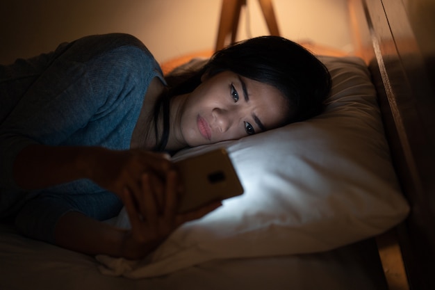 Menina chateada lendo más notícias do smartphone