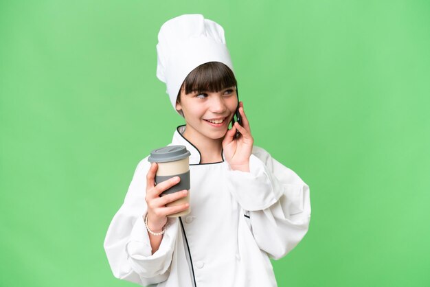 Menina chef caucasiana sobre fundo isolado segurando café para levar e um celular