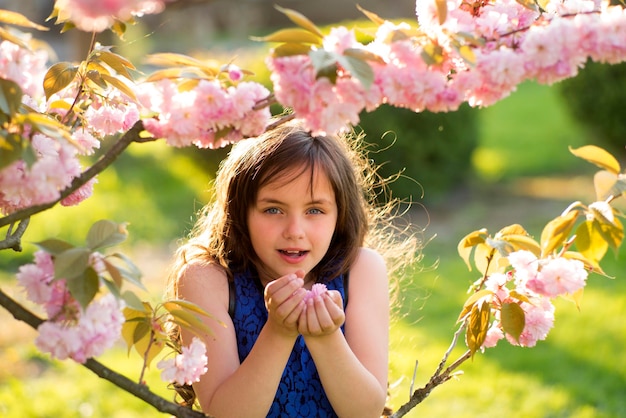 Menina cheirando flor de cereja