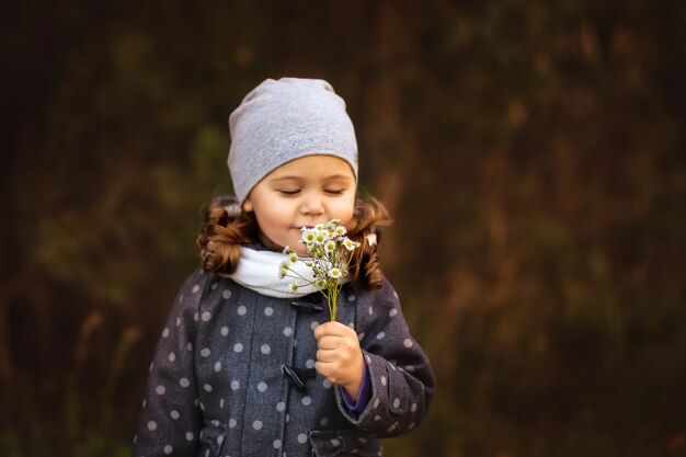 Menina cheirando flores no outono