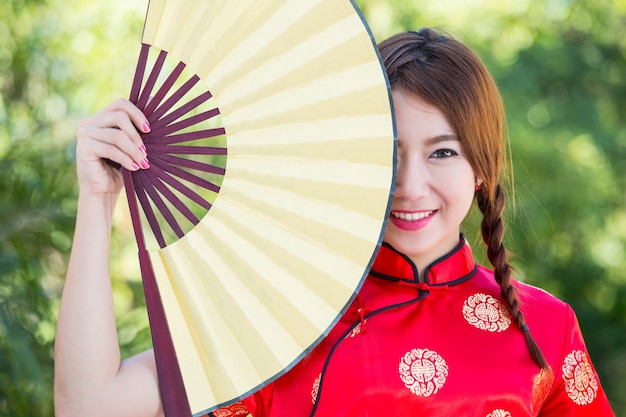 Menina chinesa com vestido tradicional Cheongsam no Jardim