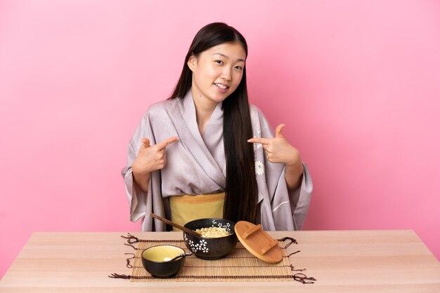 Menina chinesa de quimono comendo macarrão