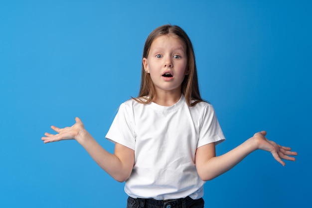 Menina chocada olhando com espanto sobre fundo azul