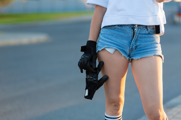 Menina closeup segurar luvas especiais para passeio de skate