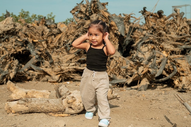 Menina cobre os ouvidos devido à poluição ambiental